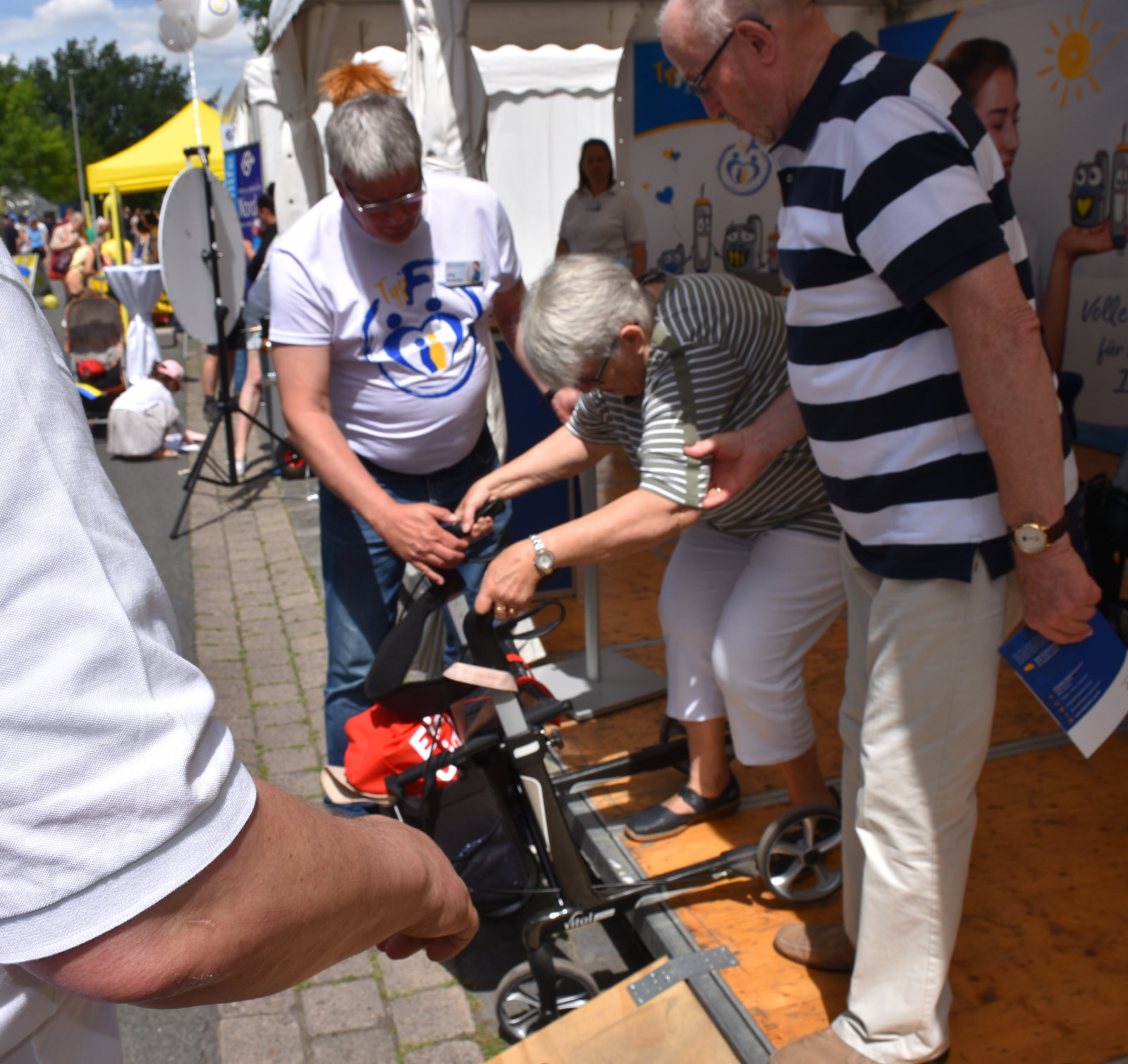 Einer Dame mit Rollator muss beim Verlassen des Zeltes geholfen werden