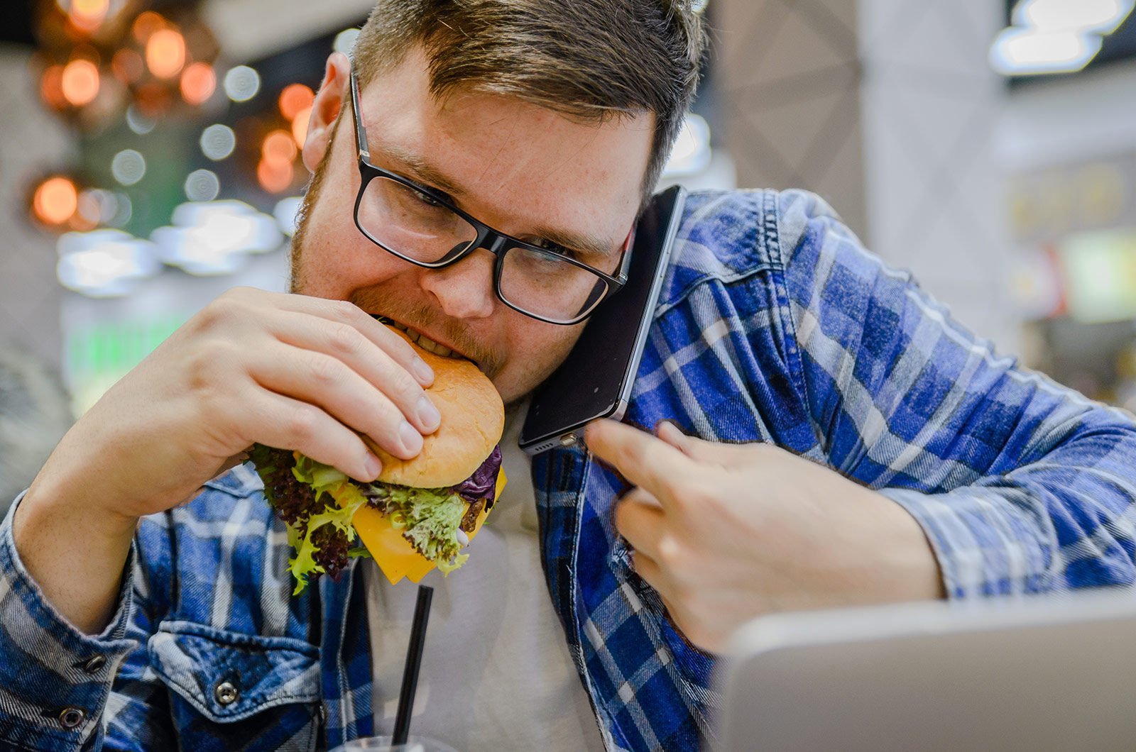 Stress am Arbeitsplatz, arbeiten am PC, telefonieren und gleichzeitig essen