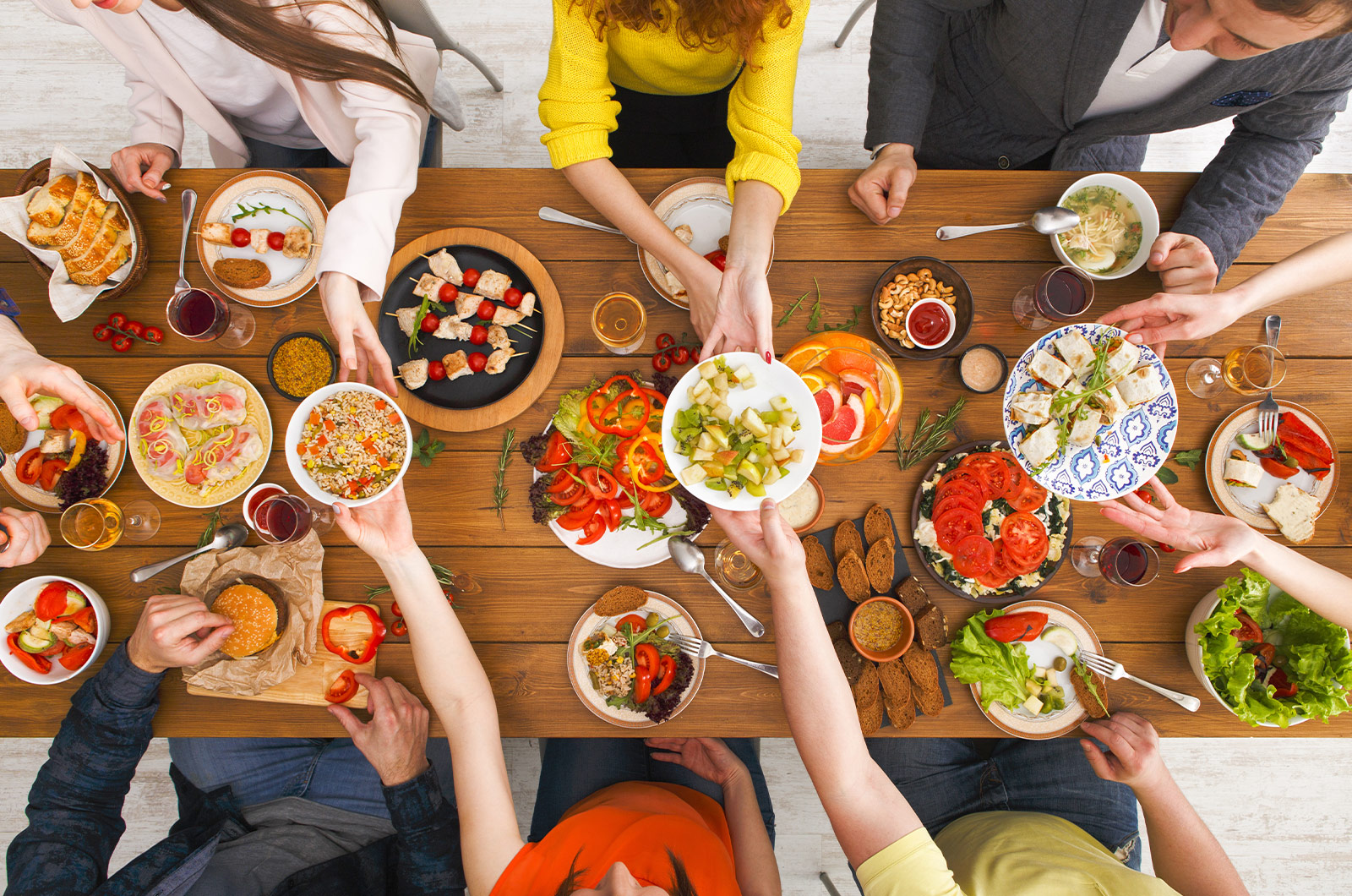 gemeinsames Essen von gesunden Mahlzeiten, serviert auf einem Holztisch