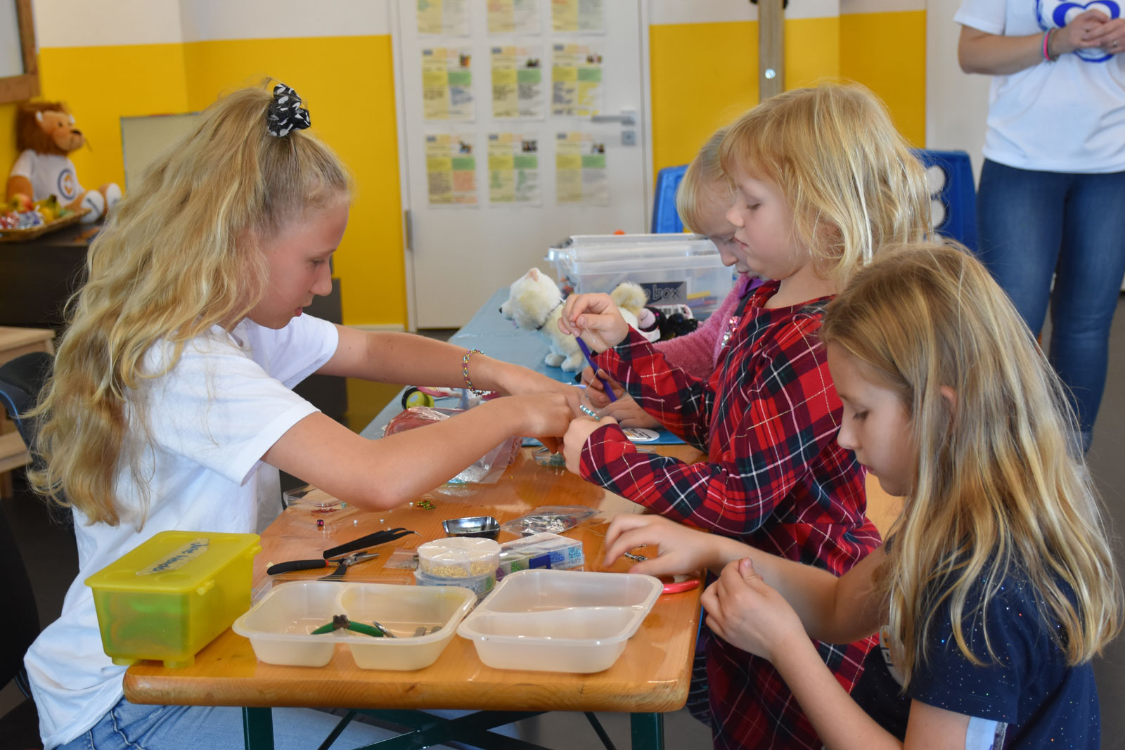Eine Grupper Kinder bastelt Schmuck
