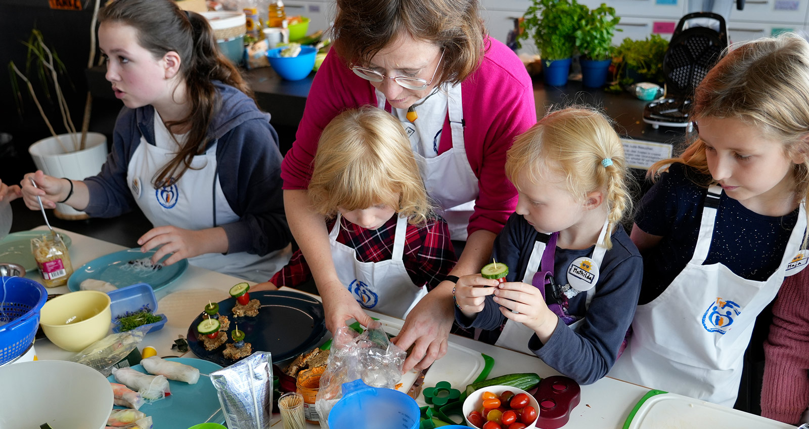 EIne Gruppe Kinder kocht beaufsichtigt durch eine Erwachsene