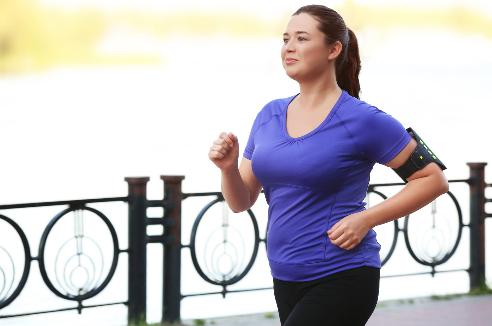 Abnehmkonzept, junge Frau joggt in der Nähe eines Flusses