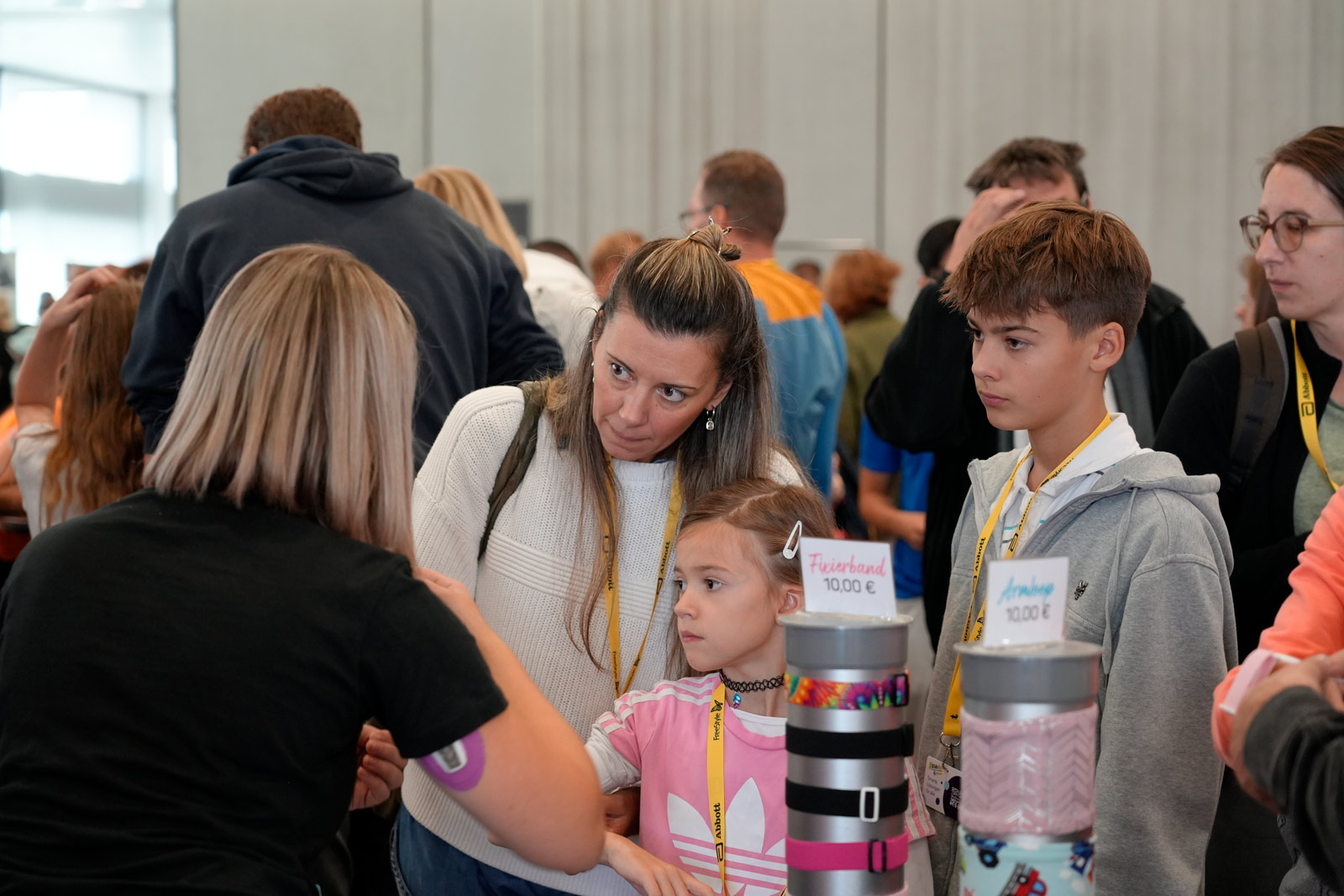 Eine Familie lässt sich an einem Infostand beraten