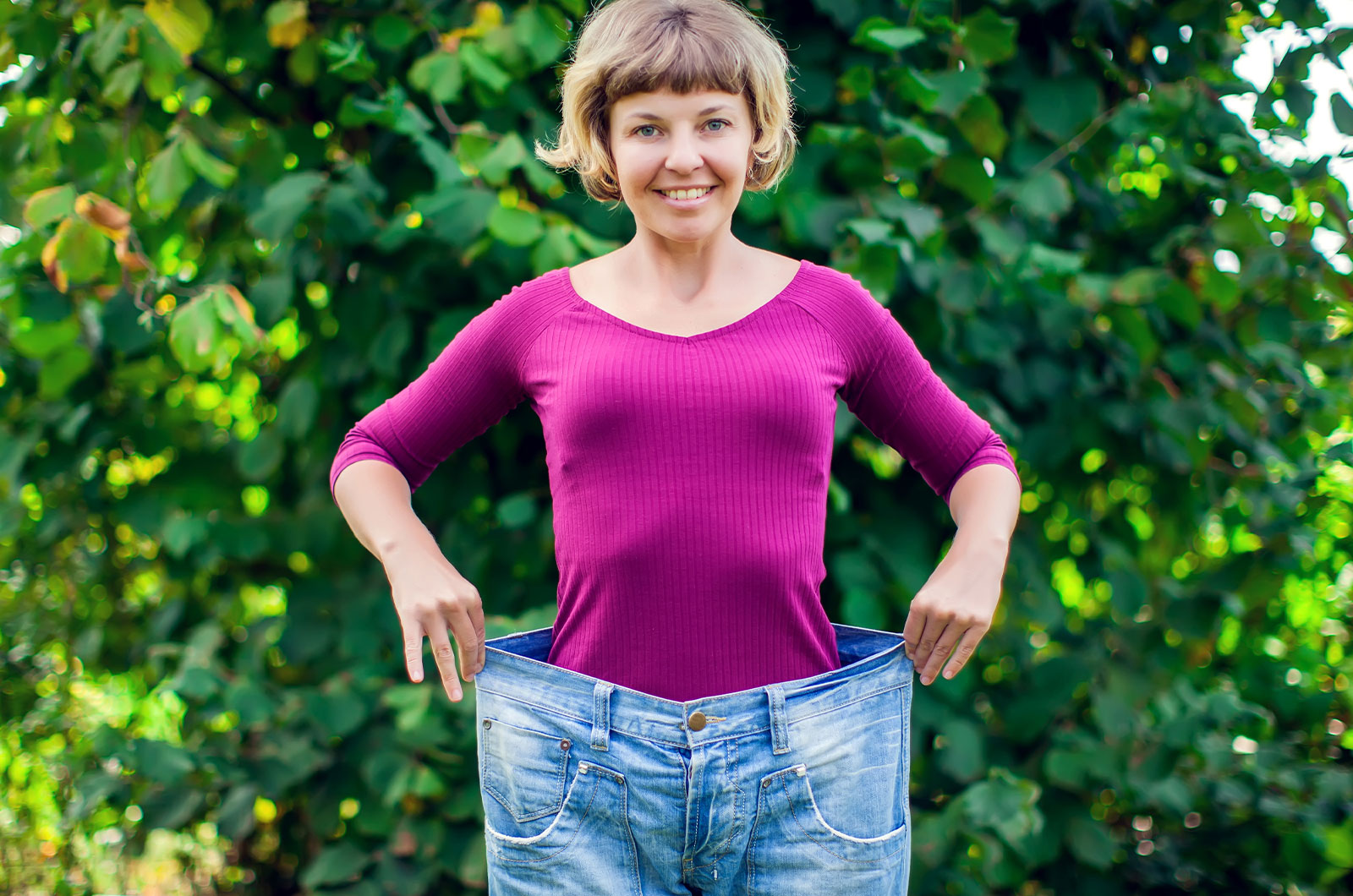 Frau mit viel zu weiter Jeans, radikale Gewichtsabnahme,