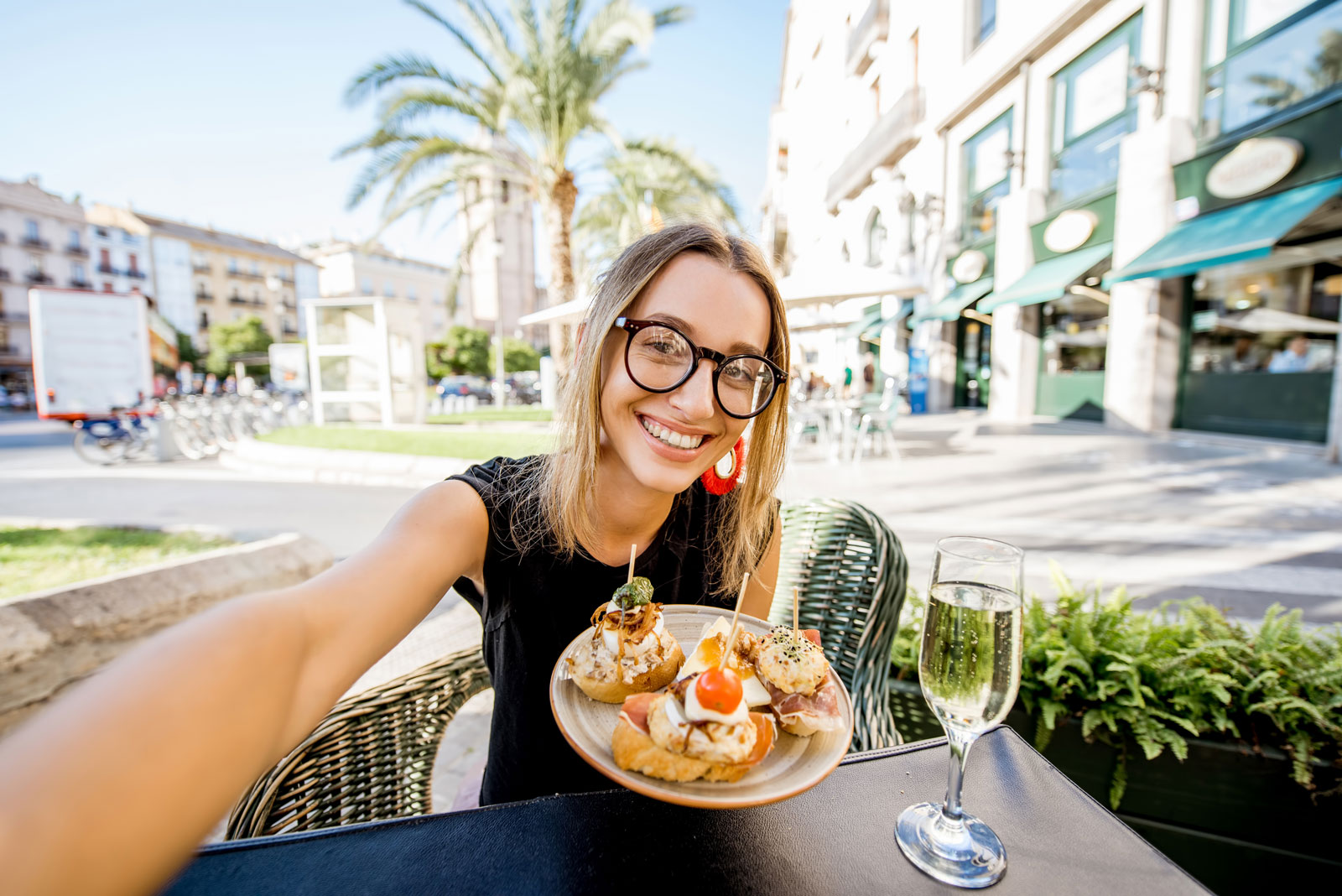 Eine junge Frau ist begeistert über einen Teller mit mediterran belegten Scheiben Brot