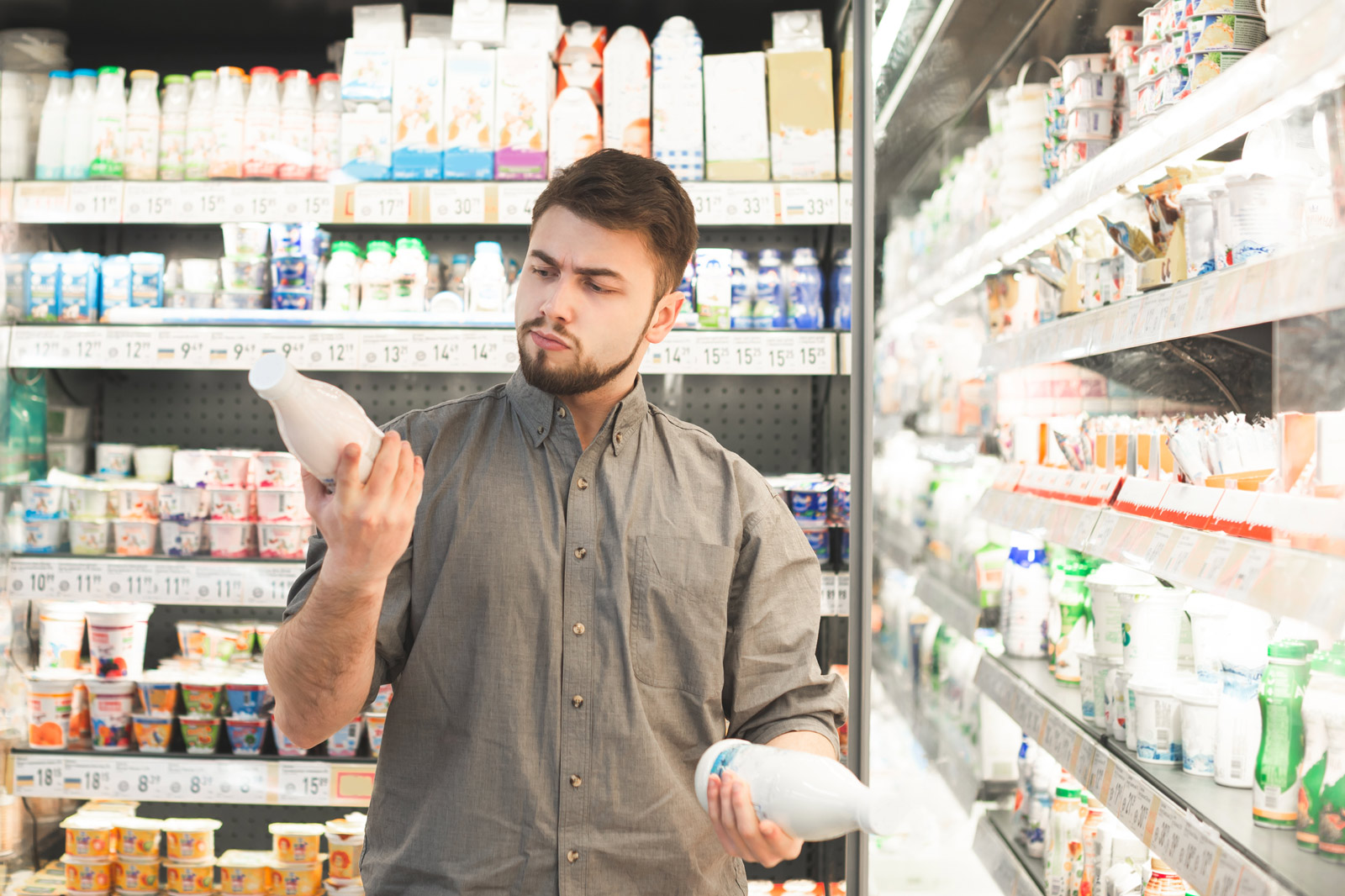 Verbraucher oft überfordert Ein Mensch wiegt zwei Getränke gegeneinander ab im Supermarkt