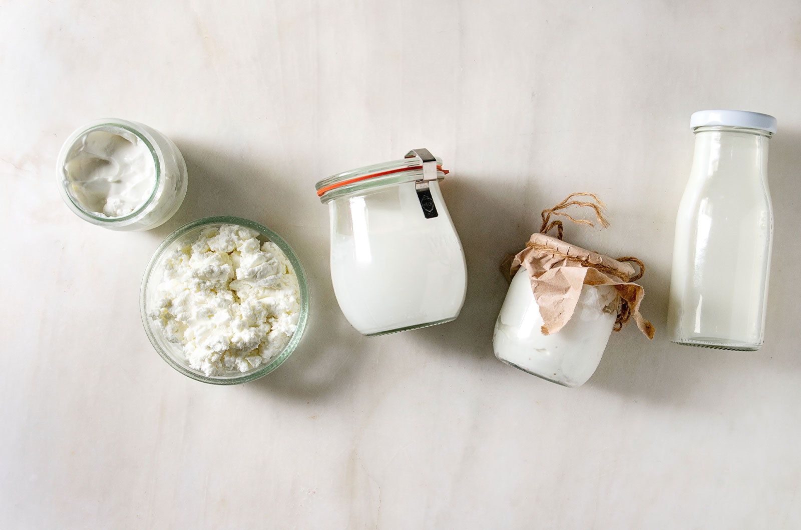 Bauernhof-Milchprodukten Hüttenkäse, Milchcreme, Naturjoghurt in wiederverwendbaren umweltfreundlichen Gläsern und Flaschen