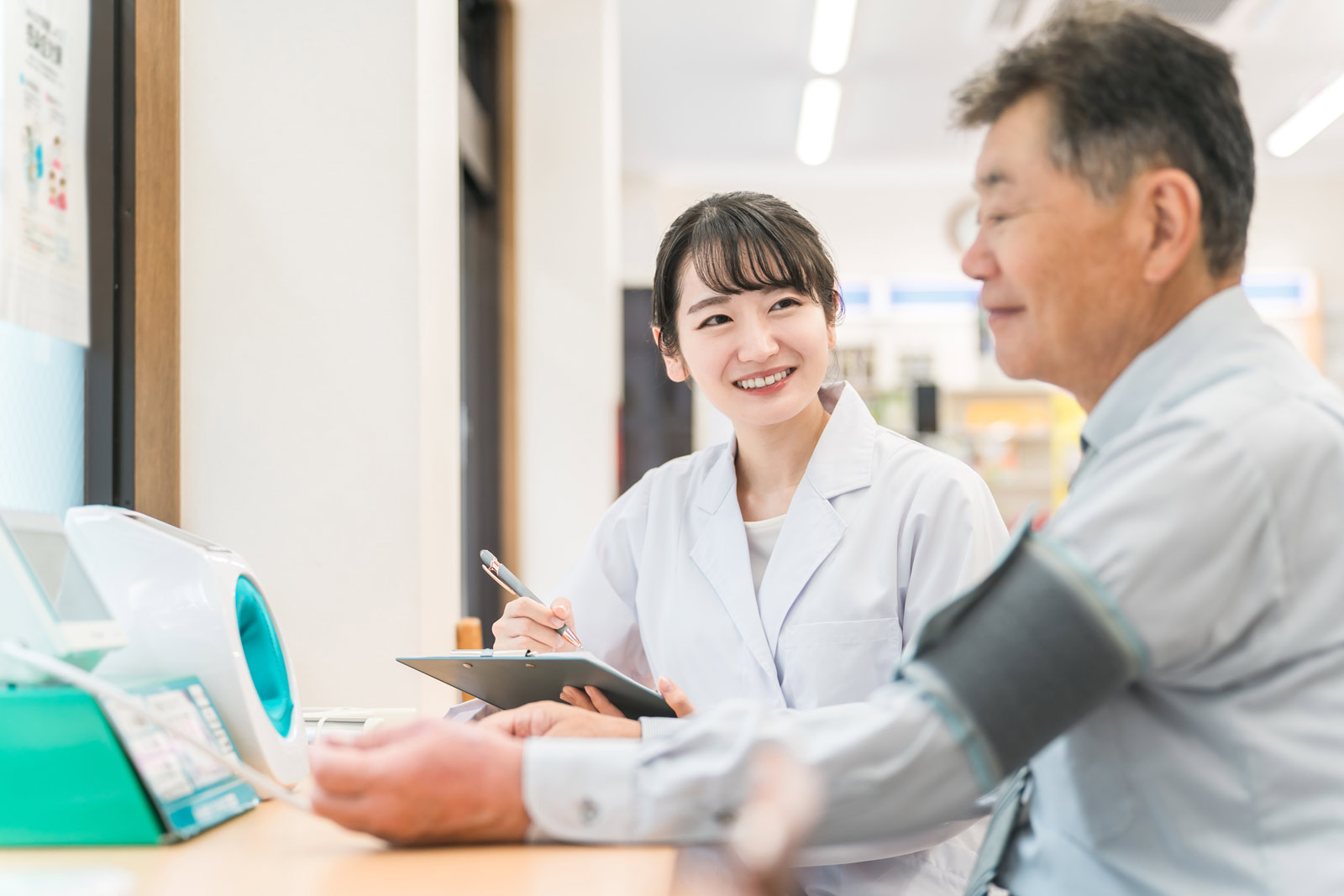 Eine chinesische Wissenschaftlern misst einem Mann den Blutdruck