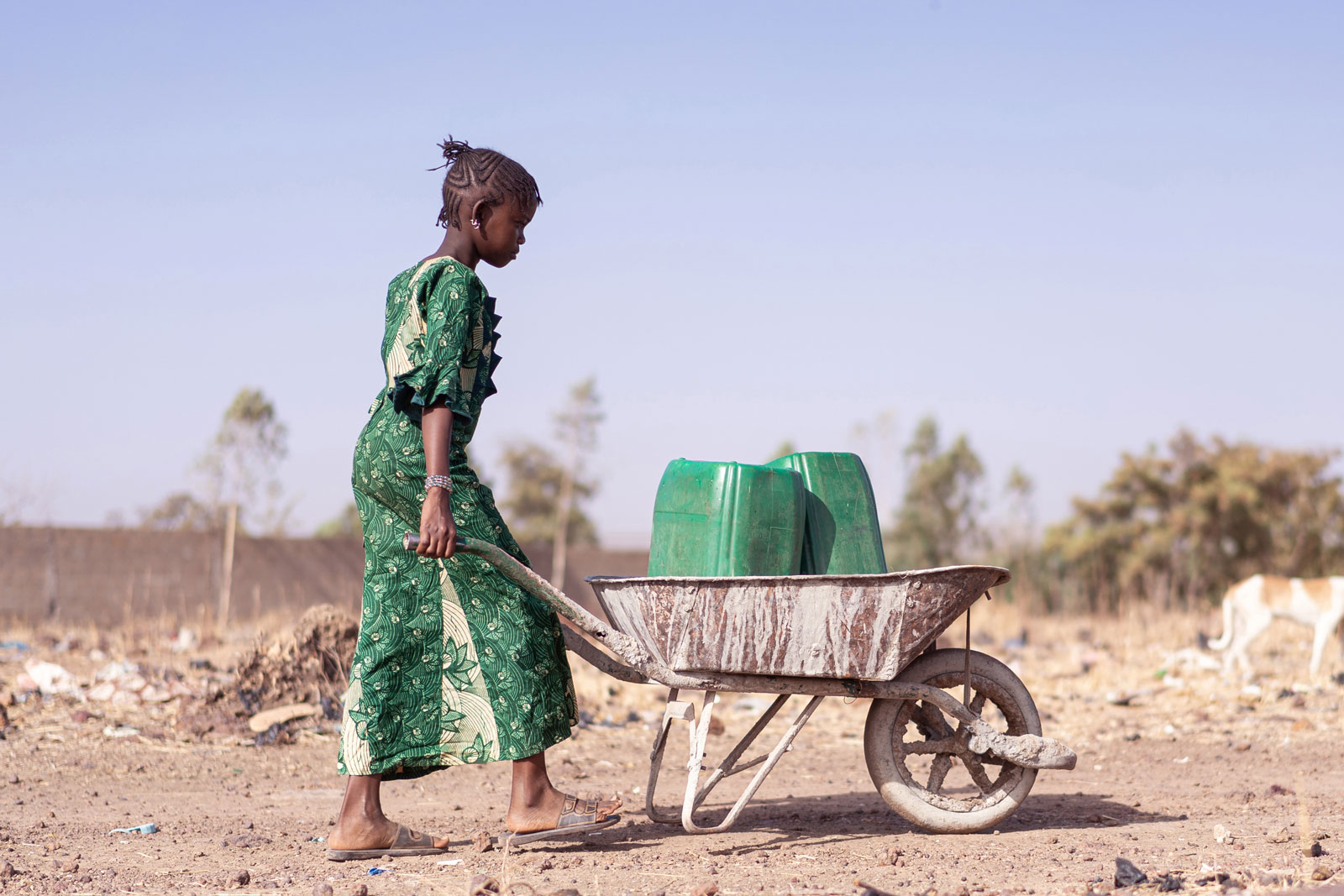 Eine Frau in Afrika entsprgt Müllkanister