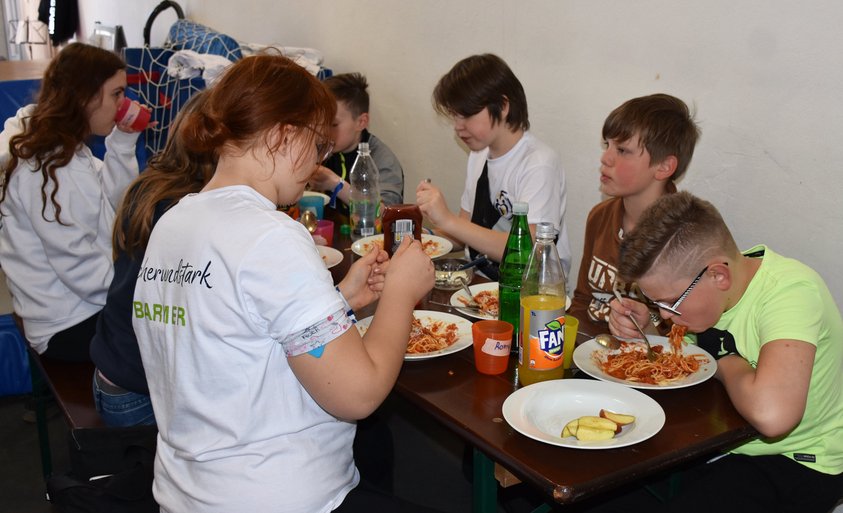 Kinder beim gemeinsamen Spaghetti-Essen.