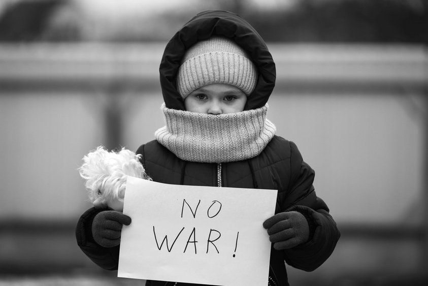 Ein Kind hält ein Schild hoch mit der Aufschrift: "No War!"